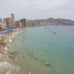 Crowded Levante beach in Benidorm under a July sun, skyline behind