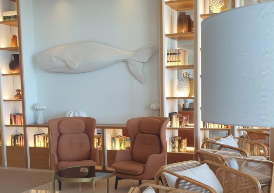 The lounge at the H10 Porto Poniente in Benidorm, with a white whale sculpture above backlit bookshelves