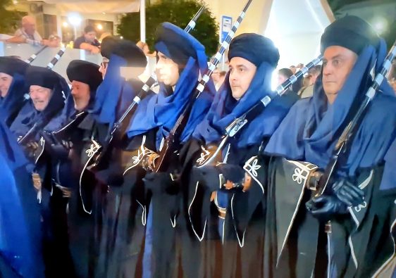 Members of a filà in blue robes shouldering muskets at the Moros y Cristianos in Benidorm