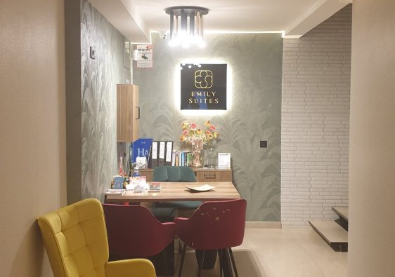 Emily Suites reception in Benidorm Old Town, yellow armchair and lit sign