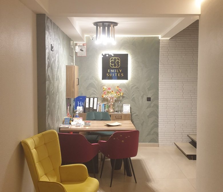 Emily Suites reception in Benidorm Old Town, yellow armchair and lit sign